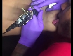 Horny tattoo artist multi-tasking sucking client'_s nipples