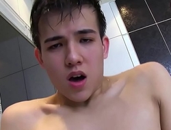 Entz&uuml_ckender asiatisch Junge Alexandre Lee, der seinen Hahn in der Badewanne erforscht